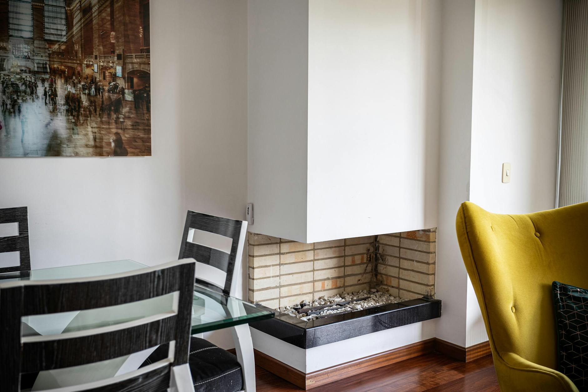 Nowoczesny salon z kominkiem, szklanym stołem i kolorowymi dodatkami