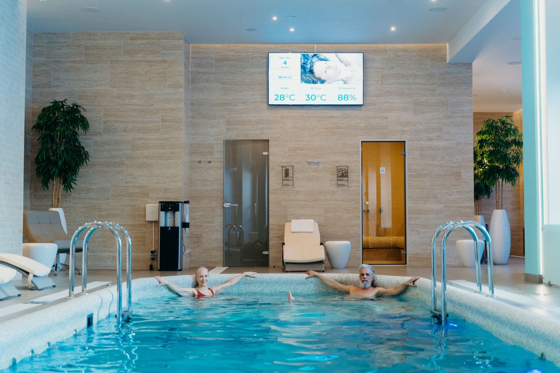 Para relaksuje się przy krytym basenie w domowej strefie spa