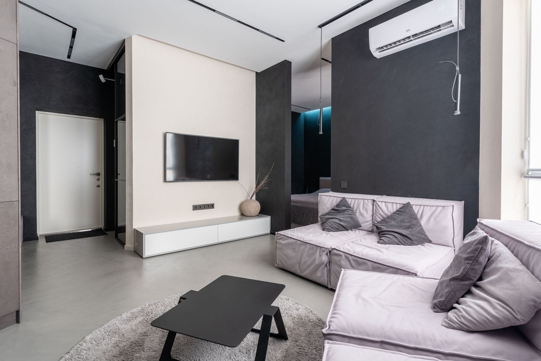 Nowoczesny przestronny salon z sofami, poduszkami i telewizorem na ścianie