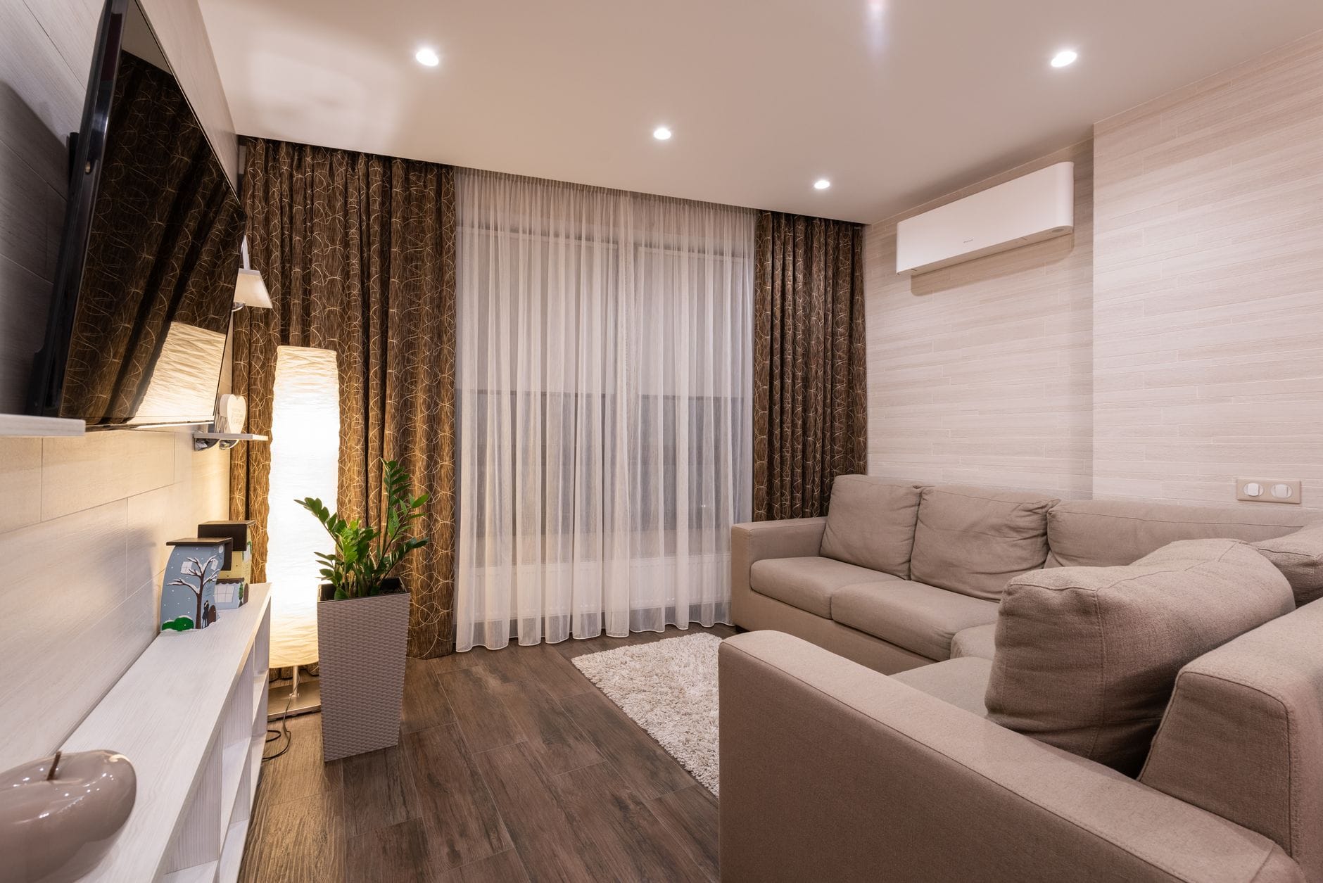 Przytulny salon z sofą, drewnianą podłogą i ciepłym oświetleniem Przytulny salon z sofą, drewnianą podłogą i ciepłym oświetleniem